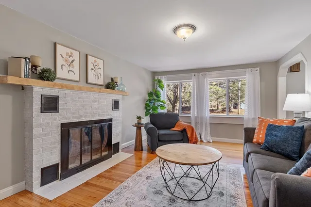 a living room with furniture a fireplace and a large window