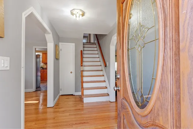 a view of a hallway with wooden floor and staircase