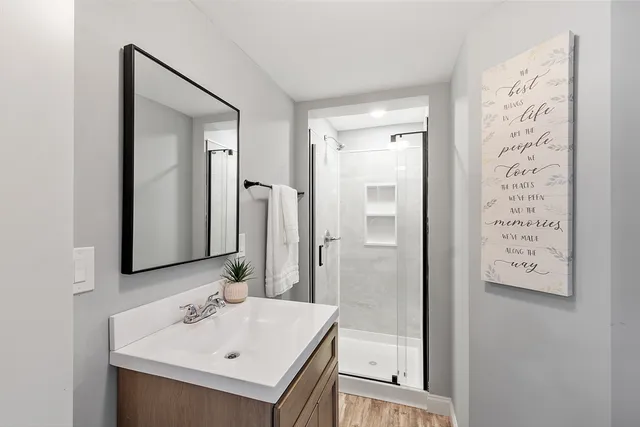 a bathroom with a sink mirror and shower