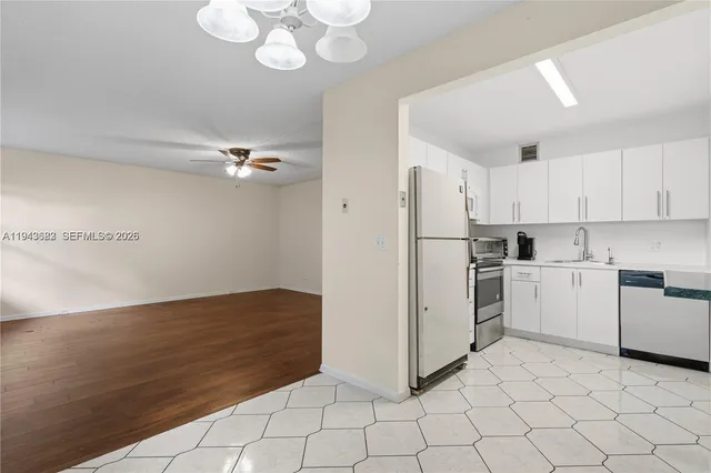 a kitchen with white cabinets and white appliances