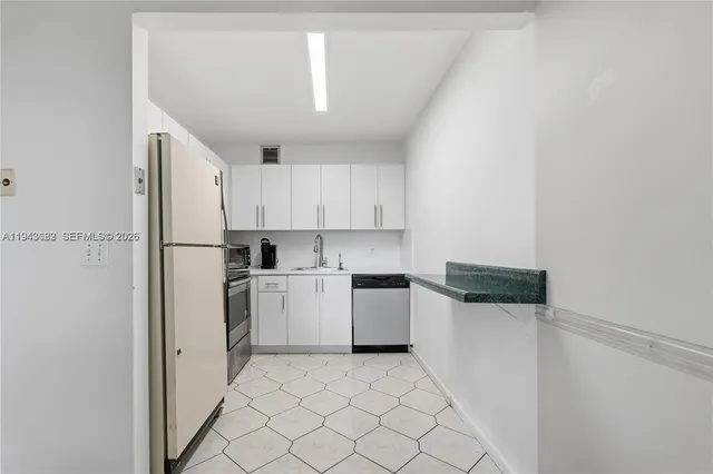 a kitchen with white cabinets and white appliances