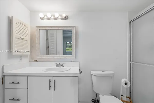 a bathroom with a sink toilet and a mirror