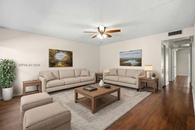 a living room with furniture and a wooden floor