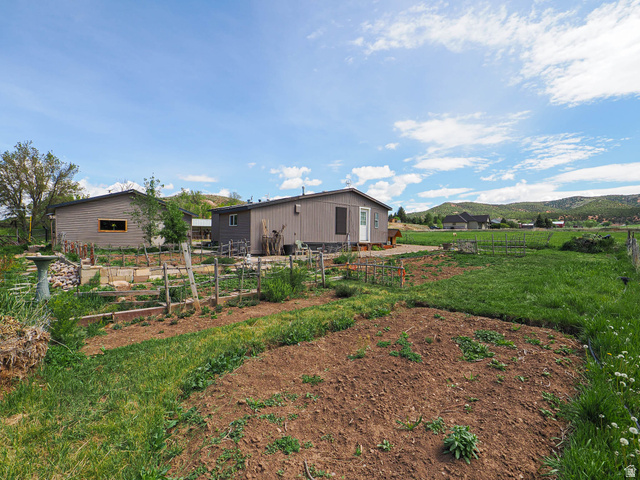 94 Spring Canyon Road Coalville, UT 84017 - Photo 7 of 50 Expansive outdoor space featuring a tilled garden area, raised garden beds, and a grass lawn