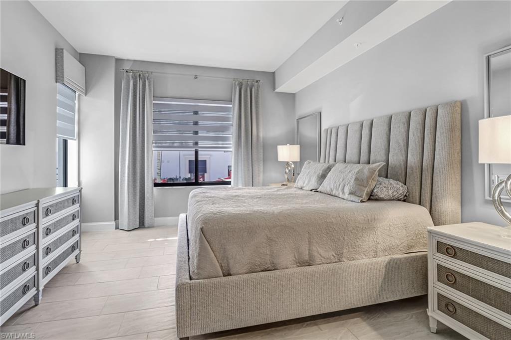 1111 Central Avenue, Unit 203 Naples, FL 34102 - Photo 11 of 19 a bedroom with a bed and a dresser