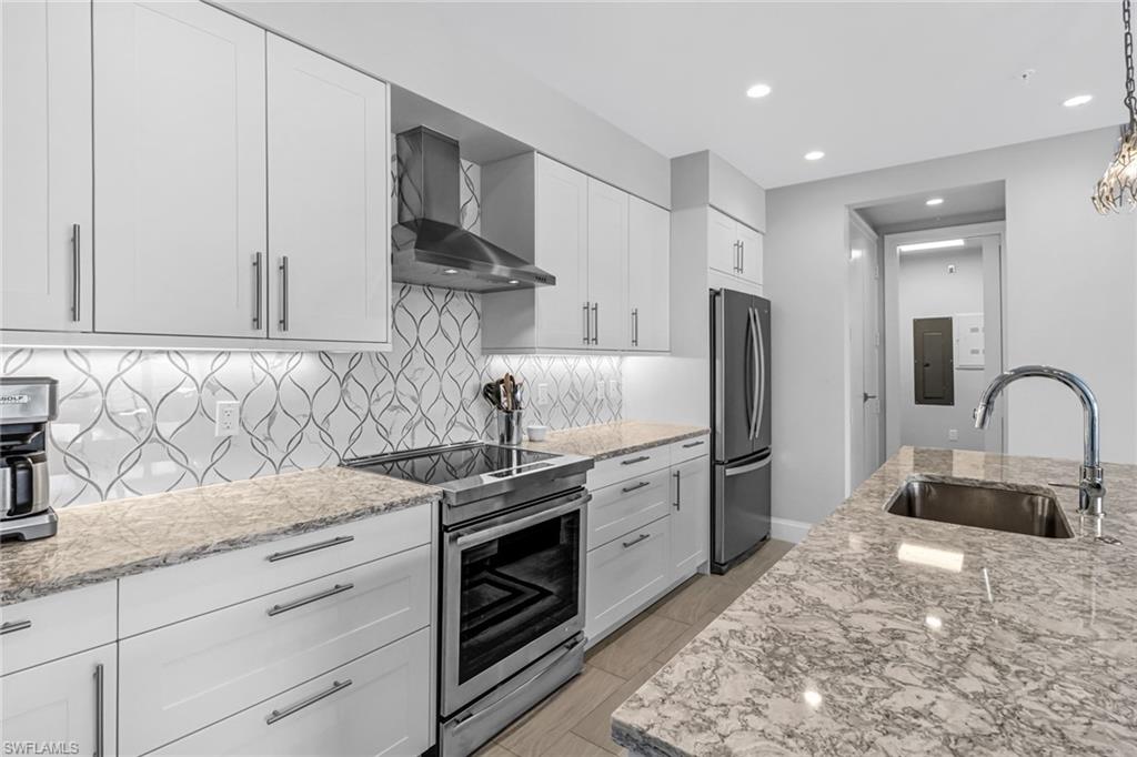 1111 Central Avenue, Unit 203 Naples, FL 34102 - Photo 4 of 19 a kitchen with stainless steel appliances granite countertop a sink stove and refrigerator