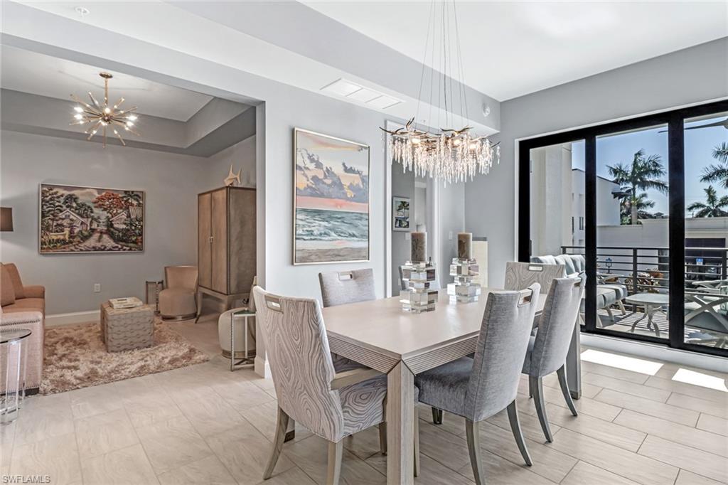 1111 Central Avenue, Unit 203 Naples, FL 34102 - Photo 6 of 19 a dining room with furniture a chandelier and window