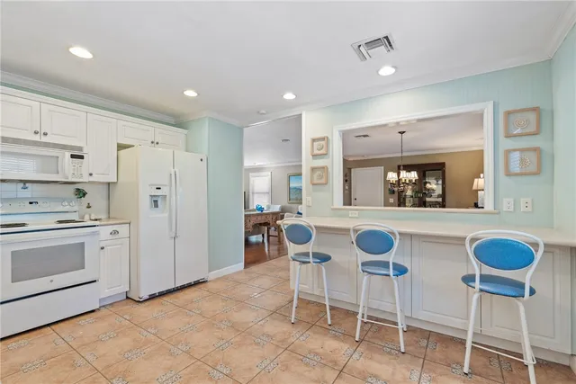 a kitchen with granite countertop white cabinets and white stainless steel appliances