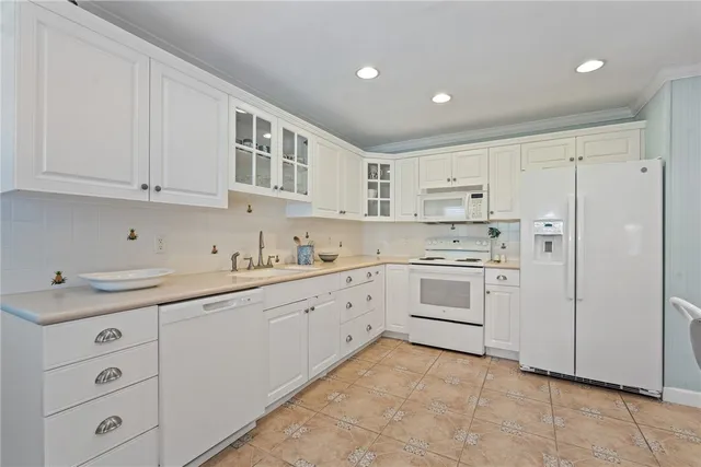 a view of a kitchen with a sink a window and chairs