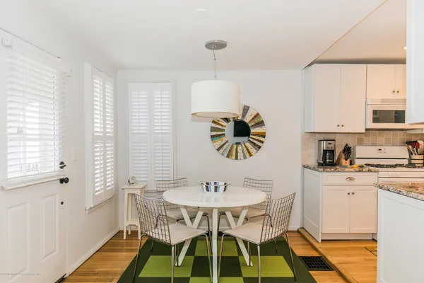 a kitchen with a dining table chairs and a sink