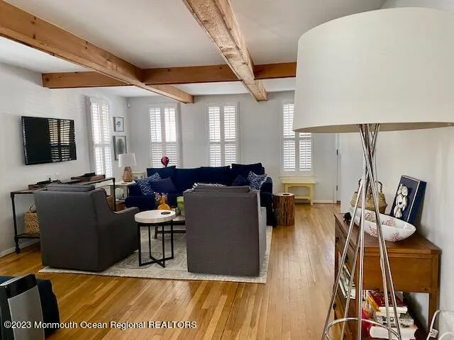 a living room with furniture a flat screen tv and wooden floor