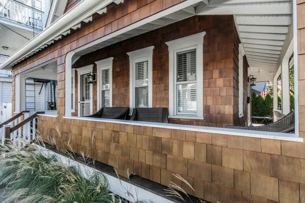 a view of a house with large windows and plants