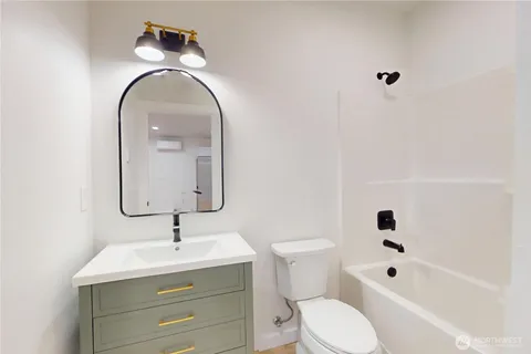 a bathroom with a toilet sink a mirror and bathtub