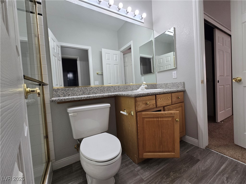 Undisclosed Address Las Vegas, NV 89149 - Photo 14 of 34 Full bath featuring vanity, dark wood finished floors, a shower with shower door, and a textured wall