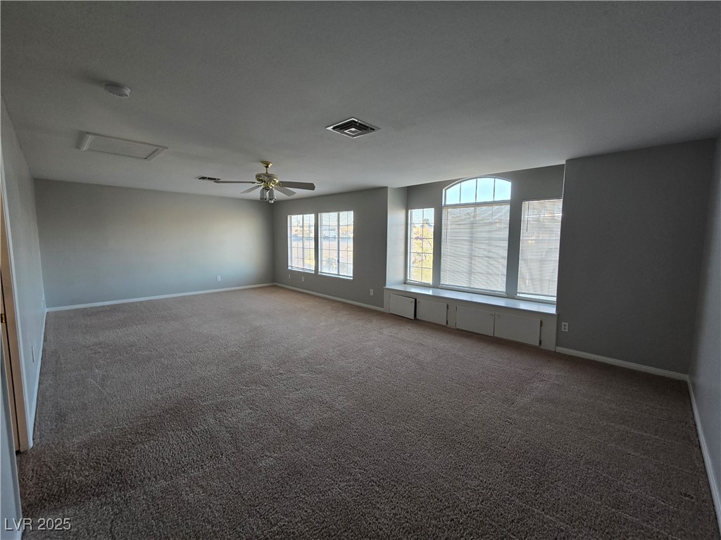 Undisclosed Address Las Vegas, NV 89149 - Photo 19 of 34 Spare room with dark carpet, ceiling fan, and attic access