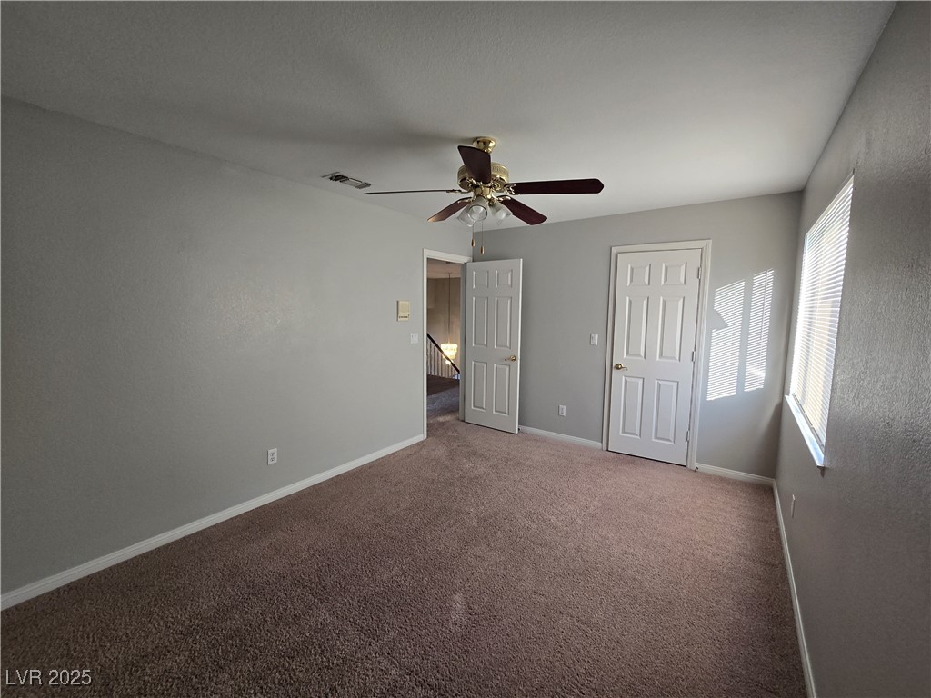 Undisclosed Address Las Vegas, NV 89149 - Photo 25 of 34 Unfurnished bedroom featuring dark carpet and ceiling fan
