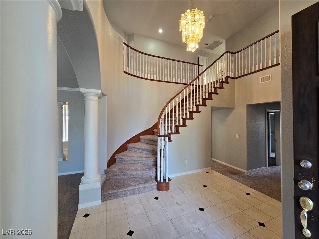 Undisclosed Address Las Vegas, NV 89149 - Photo 3 of 34 Foyer featuring a towering ceiling, light tile patterned floors, light colored carpet, a chandelier, and stairs