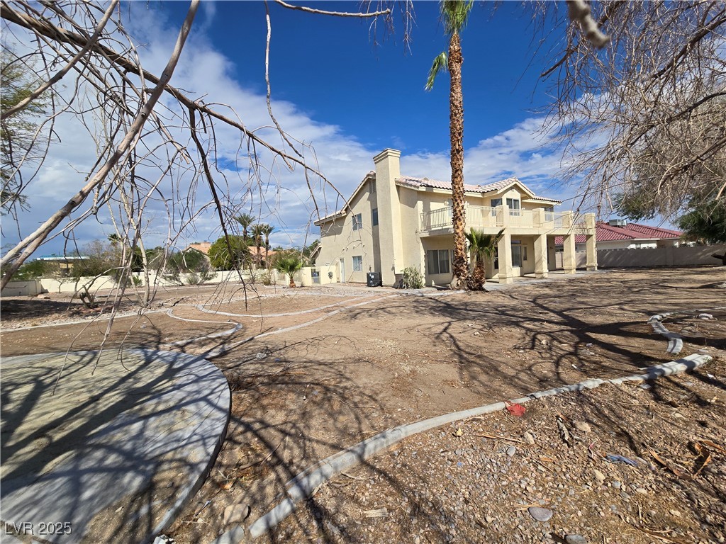 Undisclosed Address Las Vegas, NV 89149 - Photo 32 of 34 Rear view of property featuring stucco siding, a chimney, and a tiled roof