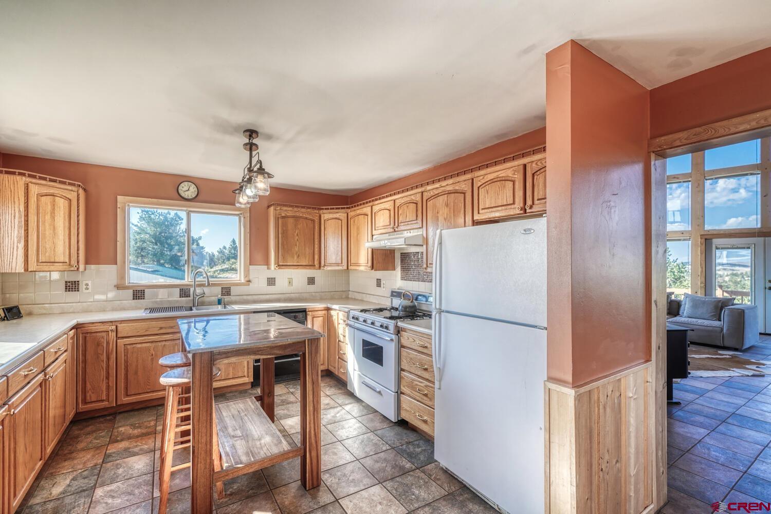 741 Wolfe Road Hartsel, CO 80449 - Photo 14 of 45 a kitchen with refrigerator a stove and wooden cabinets
