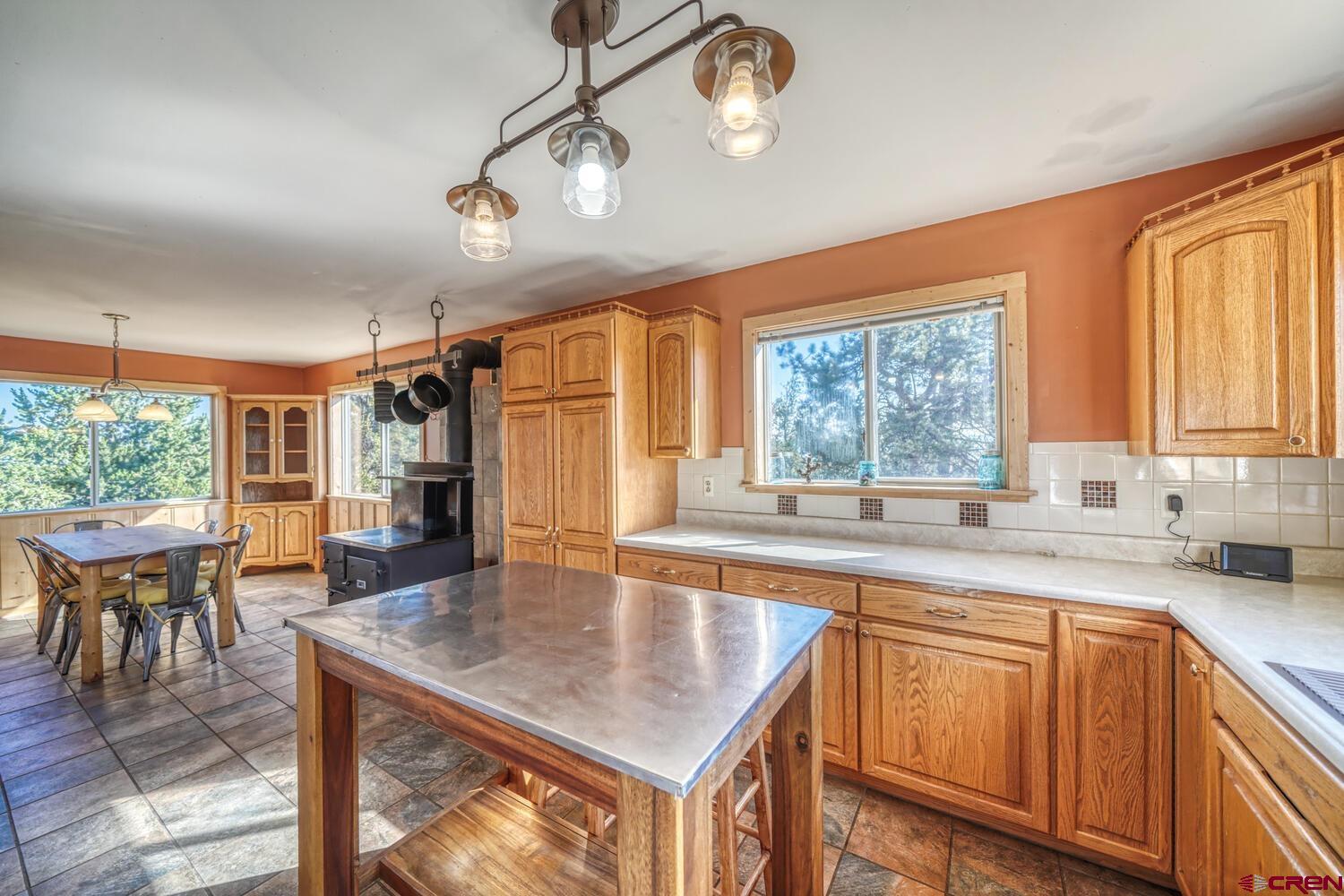 741 Wolfe Road Hartsel, CO 80449 - Photo 16 of 45 a kitchen with a stove a sink dishwasher a dining table and chairs with wooden floor