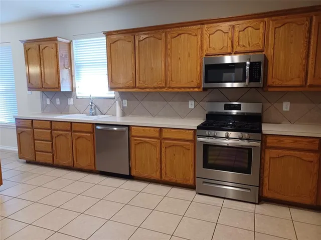 a kitchen with stainless steel appliances granite countertop a stove microwave and sink
