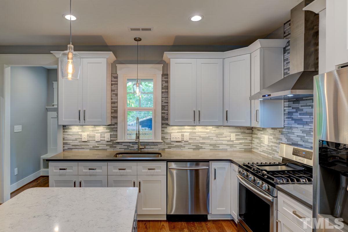 1416 East Jones Street Raleigh, NC 27610 - Photo 5 of 30 a kitchen with kitchen island granite countertop a sink a counter space appliances and cabinets