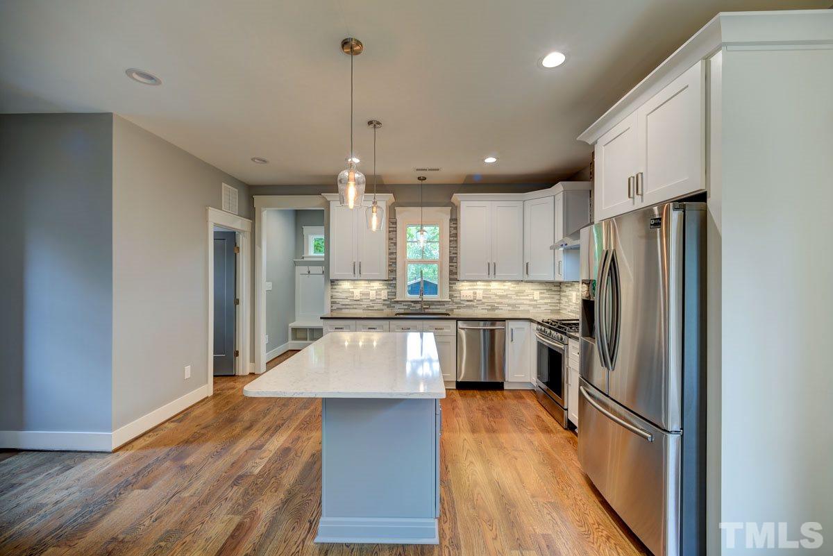 1416 East Jones Street Raleigh, NC 27610 - Photo 10 of 30 a kitchen with stainless steel appliances granite countertop a refrigerator a sink dishwasher a stove and white countertops with wooden floor