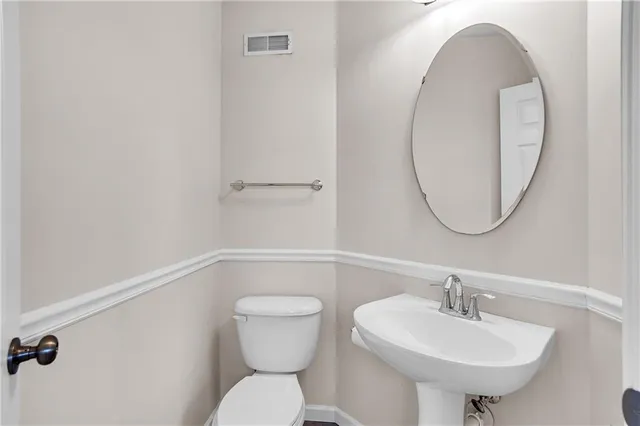 a bathroom with a sink mirror and toilet