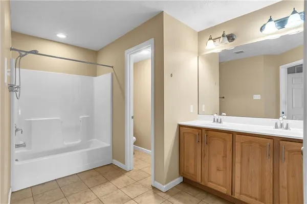 a spacious bathroom with a glass shower door and a mirror