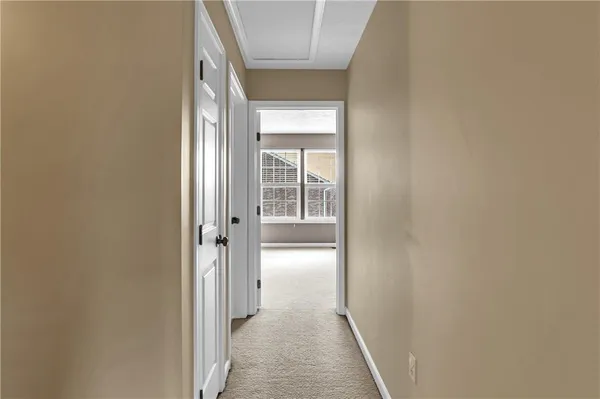 a view of a hallway with wooden floor and a window