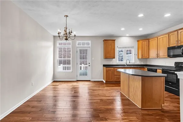 a large kitchen with stainless steel appliances granite countertop a stove and a wooden floors