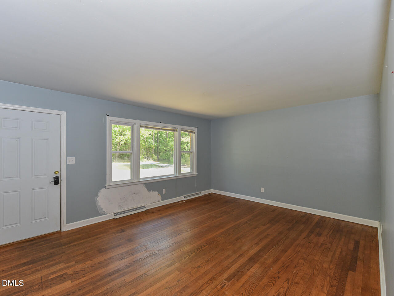 1703 St Patrick Drive Raleigh, NC 27603 - Photo 10 of 29 a view of an empty room with wooden floor and a window