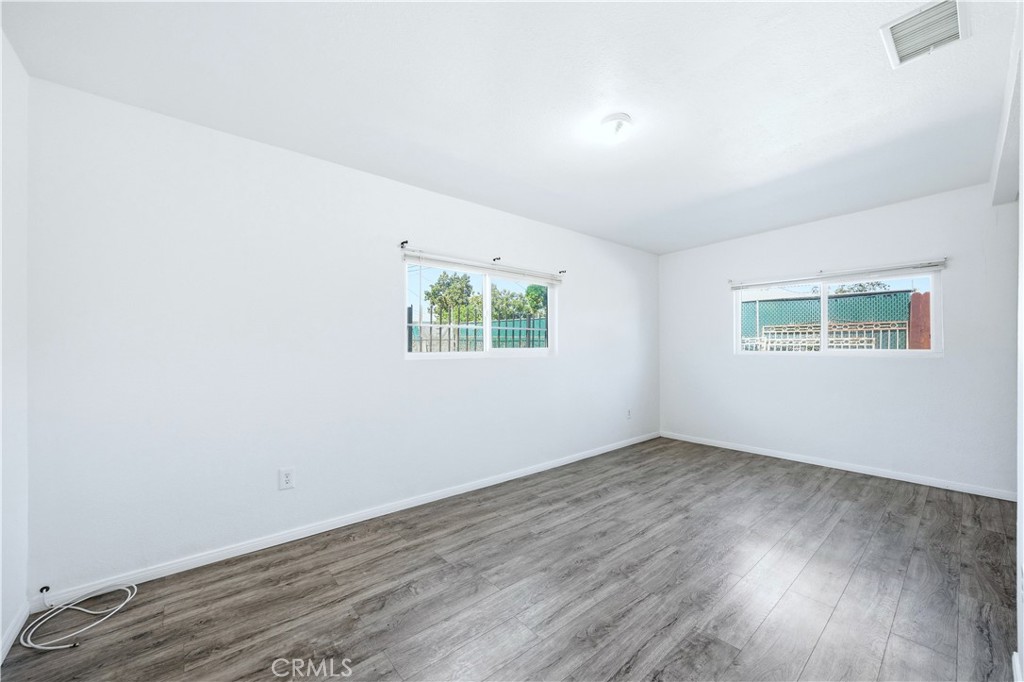 1619 West 163rd Street Compton, CA 90220 - Photo 25 of 36 an empty room with wooden floor and windows