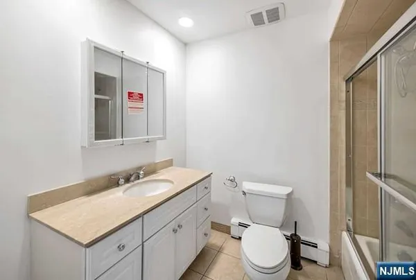 a bathroom with a toilet sink vanity and mirror