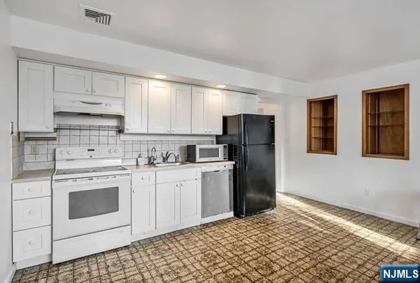 a kitchen with stainless steel appliances granite countertop a refrigerator sink and stove