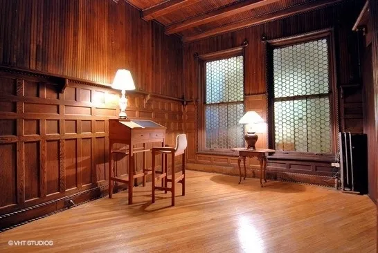 an empty room with windows wooden floor and furniture
