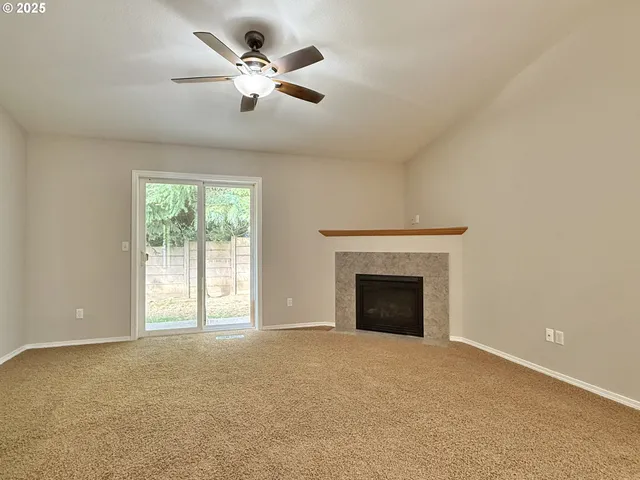 an empty room with fan and windows