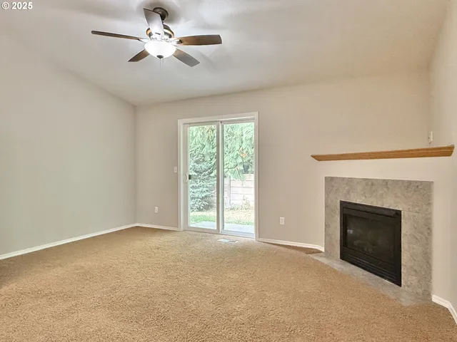 a view of empty room with a fireplace and fan
