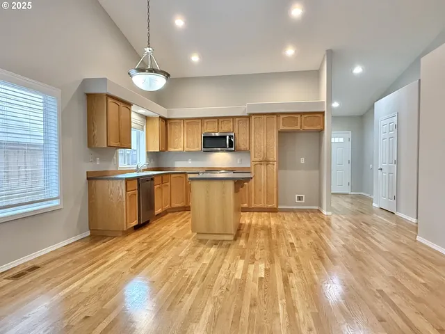 a kitchen with stainless steel appliances granite countertop a sink stove and refrigerator