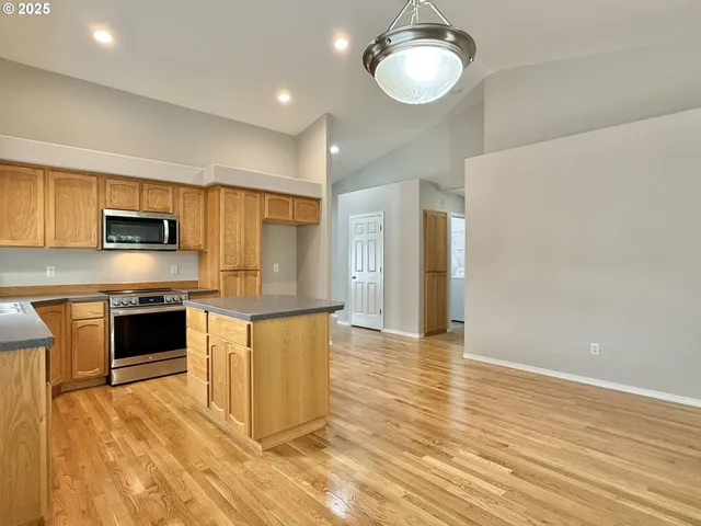 a view of kitchen with stainless steel appliances granite countertop cabinets and wooden floor