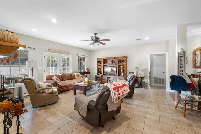 a kitchen with stainless steel appliances a stove a sink a refrigerator a center island and chairs