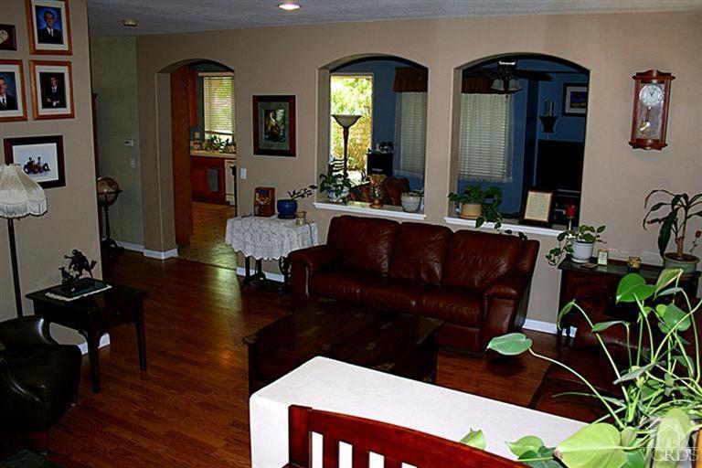 968 Roldan Avenue Simi Valley, CA 93065 - Photo 3 of 20 a living room with couches chairs and paintings on the wall with wooden floor