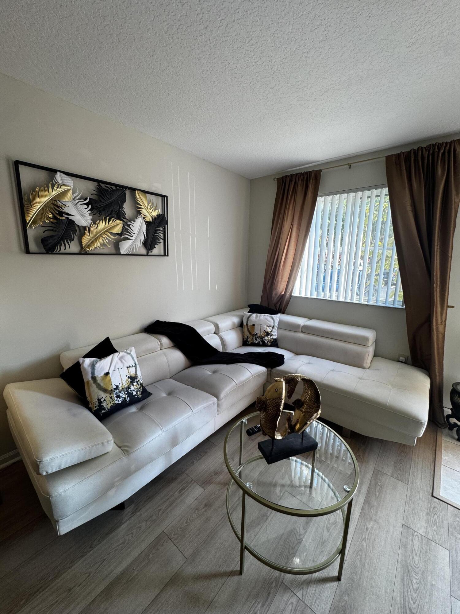 3810 North Jog Road, Unit 105 Royal Palm Beach, FL 33411 - Photo 5 of 26 a living room with furniture and wooden floor