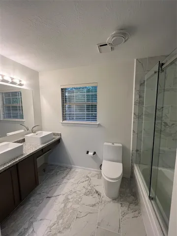 a bathroom with a toilet sink and mirror