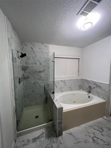 a bathroom with a bathtub and shower