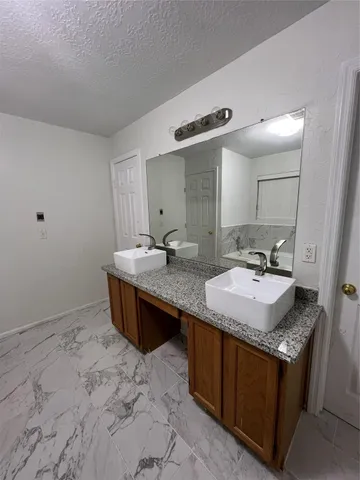 a bathroom with a granite countertop sink a mirror and a vanity