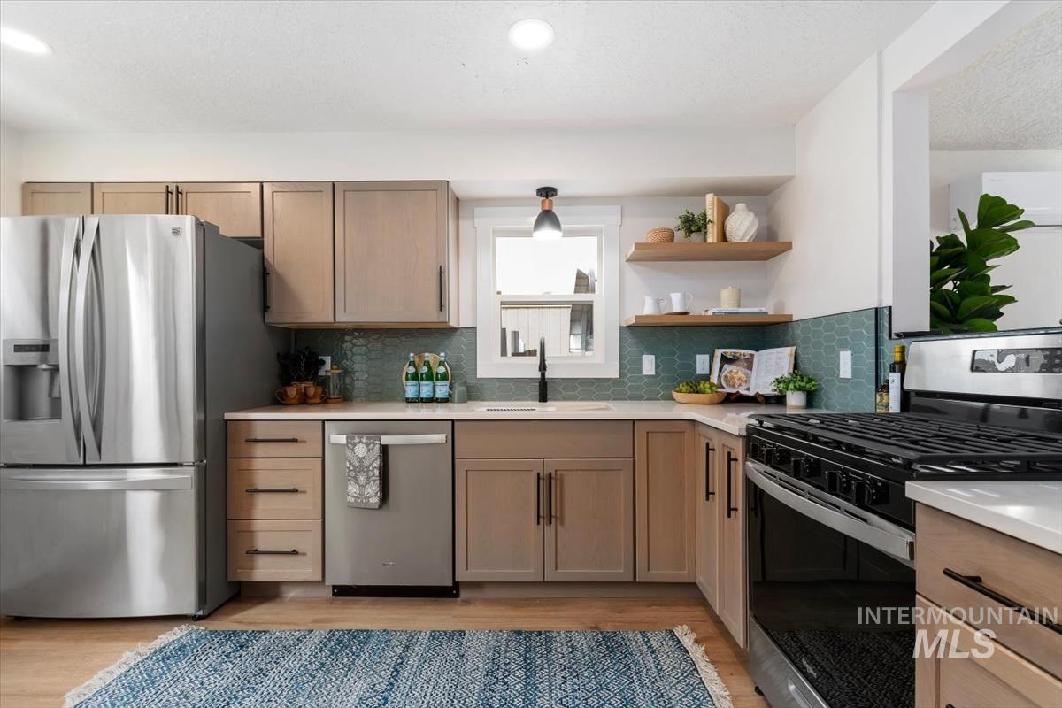 3005 West Hester Street Boise, ID 83702 - Photo 11 of 32 Kitchen with light wood-finish cabinetry, stainless steel appliances, and a hexagonal teal tile backsplash