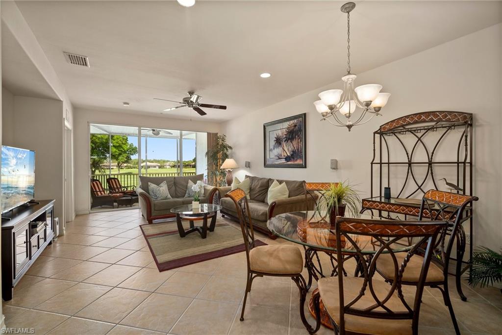9113 Michael Circle, Unit 4 Naples, FL 34113 - Photo 11 of 23 Tiled dining area with ceiling fan with notable chandelier