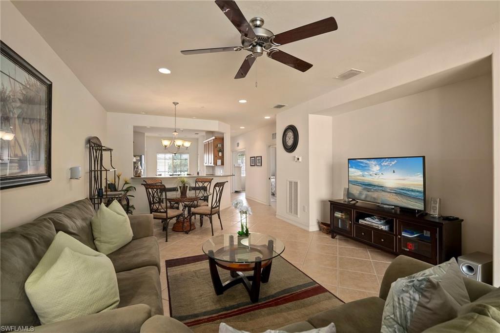 9113 Michael Circle, Unit 4 Naples, FL 34113 - Photo 13 of 23 Tiled living room with ceiling fan with notable chandelier