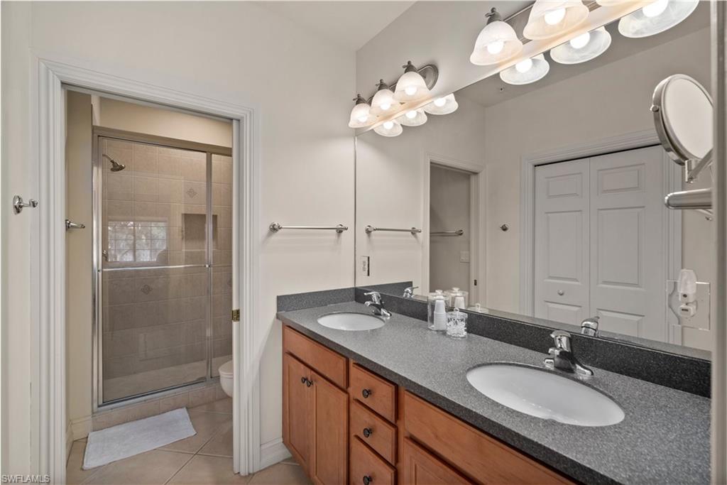 9113 Michael Circle, Unit 4 Naples, FL 34113 - Photo 20 of 23 Bathroom featuring toilet, a shower with shower door, tile floors, and double sink vanity